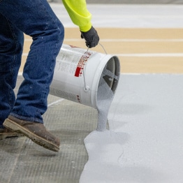 A man pouring Terapro 250 onto the application area from a bucket.