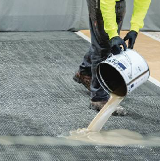 Siplast worker pouring resin on a roof