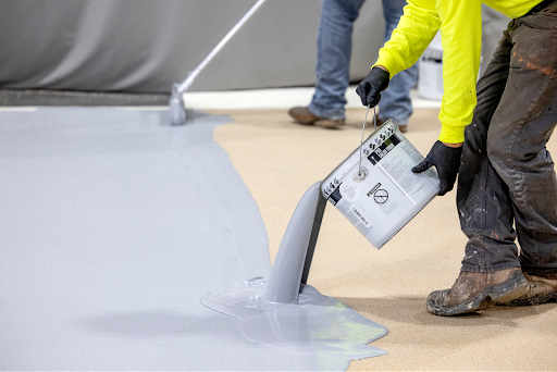 Siplast worker pouring terapro application on roof