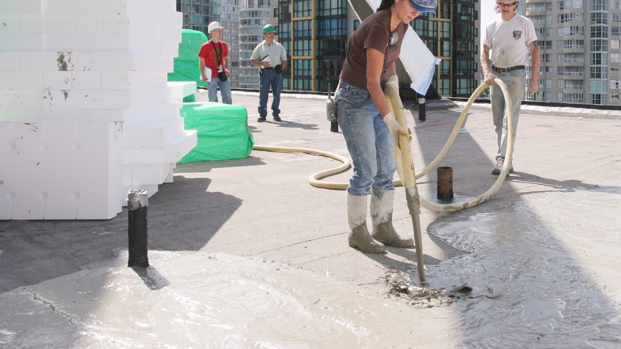 Commercial roofing contractor applying lightweight insulating concrete