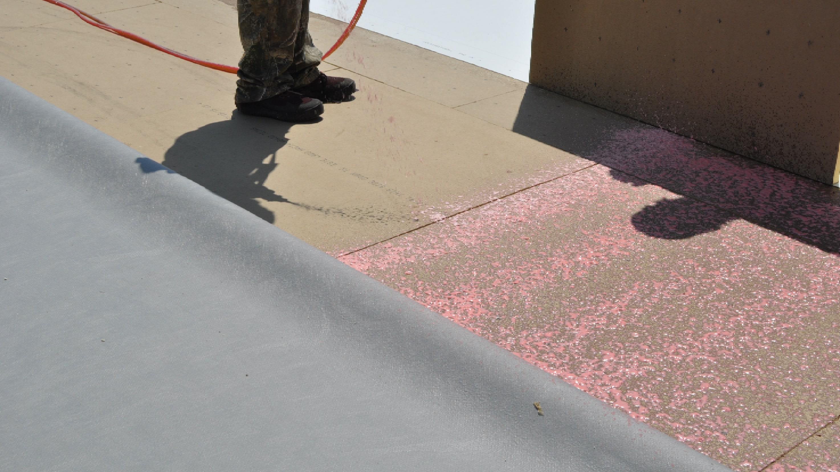 PVC roofing materials being adhered with glue