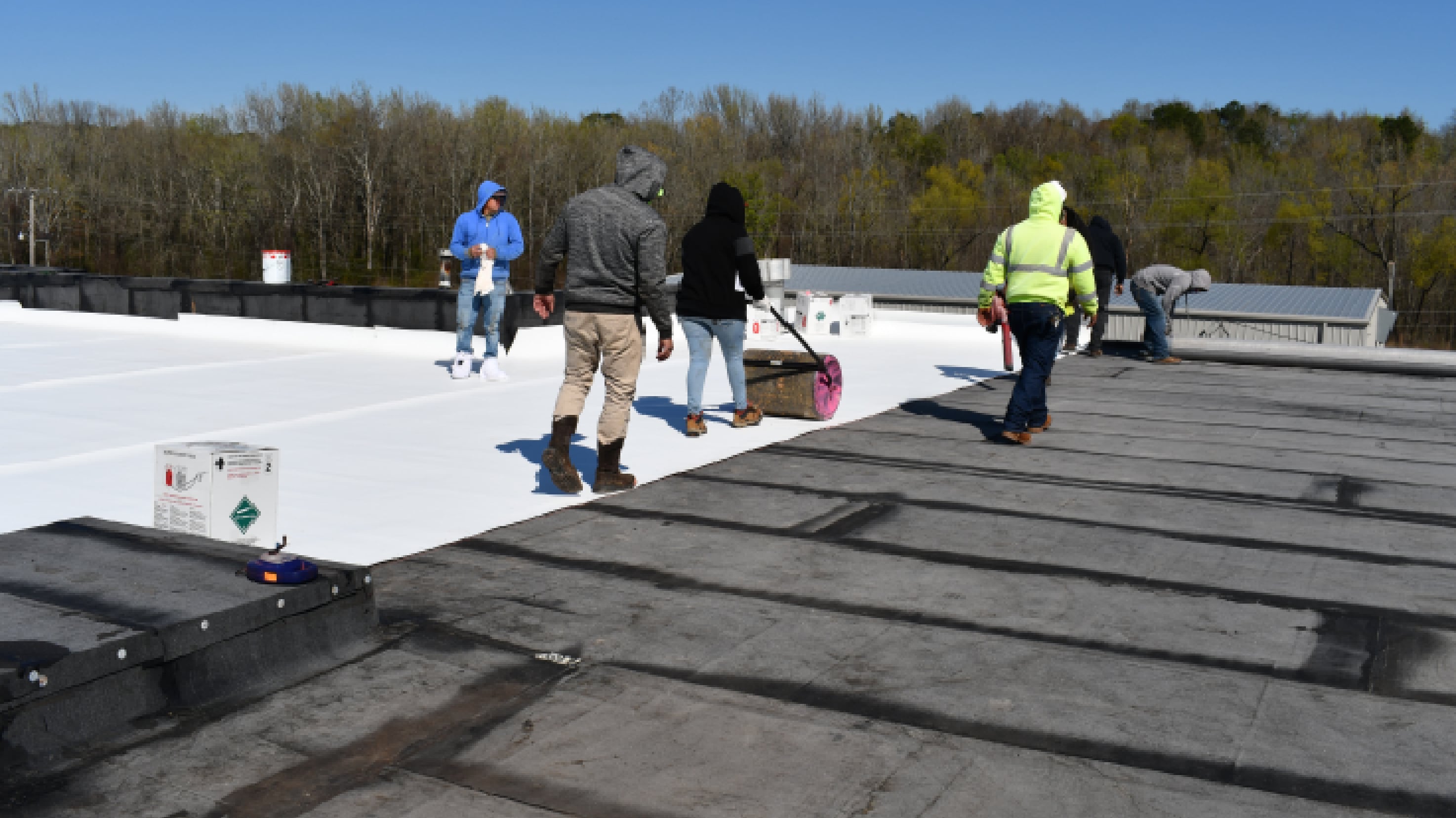 Roofers installing a hybrid PVC SBS system